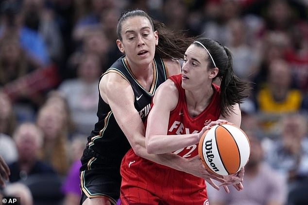 Caitlin Clark makes a pass as Liberty's Breanna Stewart defends her in the first half