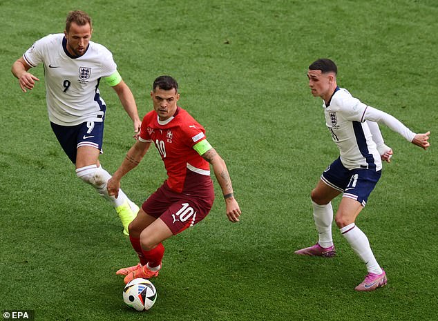 Harry Kane (L) of England and Granit Xhaka of Switzerland in action on Saturday night