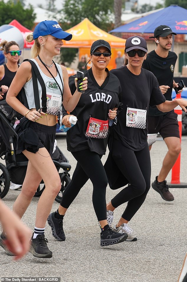 The reality star wore natural looking make up and placed a black billed cap over her dark ponytail, and finished the look with a pair of dark sunglasses as she jogged the course with friends
