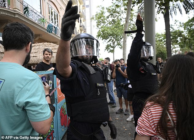 Anti-riot forces gesture as protestors put march through Las Ramblas earlier today