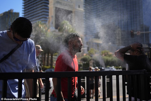 People cool off in misters along the Las Vegas Strip Sunday