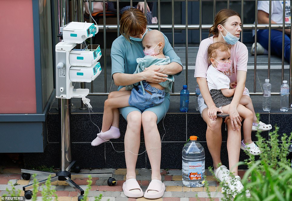 Women hold young patients at Ohmatdyt Children's Hospital that was damaged during Russian missile strikes, amid Russia's attack on Ukraine, in Kyiv, Ukraine July 8, 2024