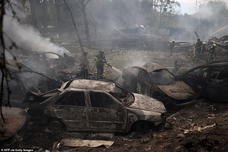 Ukrainian firefighters work to extinguish a fire at the site of a missile attack in Kyiv on July 8