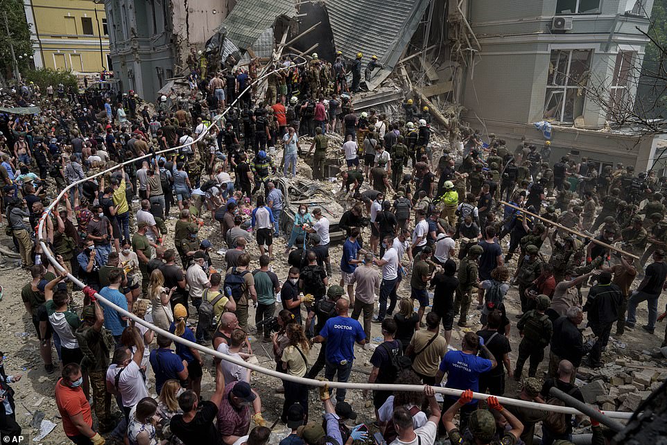 Hundreds descended on the bombed-out hospital this morning to help with rescue attempts amid reports young patients were trapped under rubble