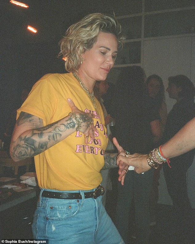 Ashlyn showed off her elaborately tattooed arms in a short-sleeved yellow shirt