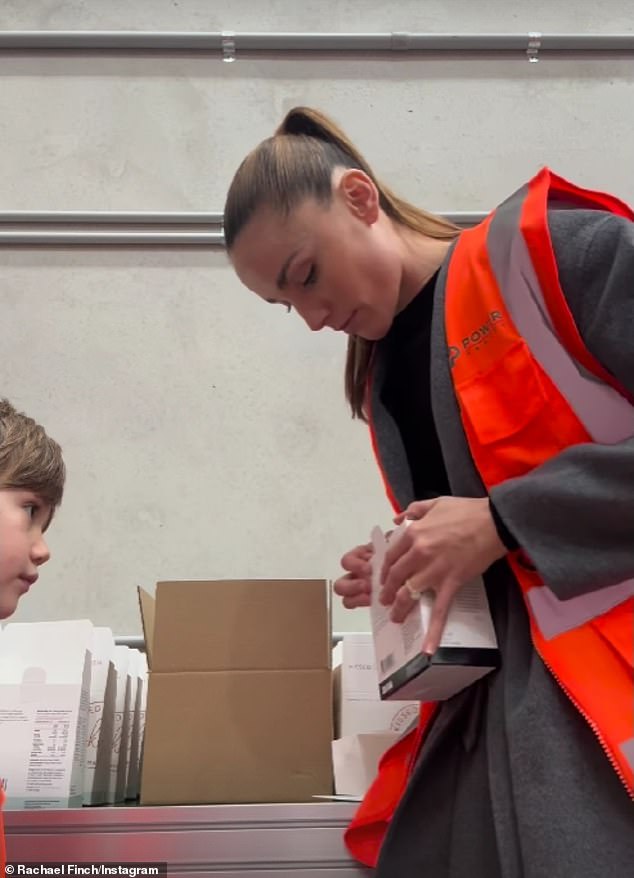 The siblings were outfitted in high-vis gear as they carefully stacked the supplements into cardboard boxes, while their mother supervised them