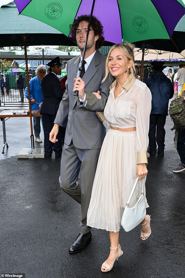 The couple made a stylish arrival at the iconic venue, as they were pictured walking arm-in-arm underneath a branded umbrella