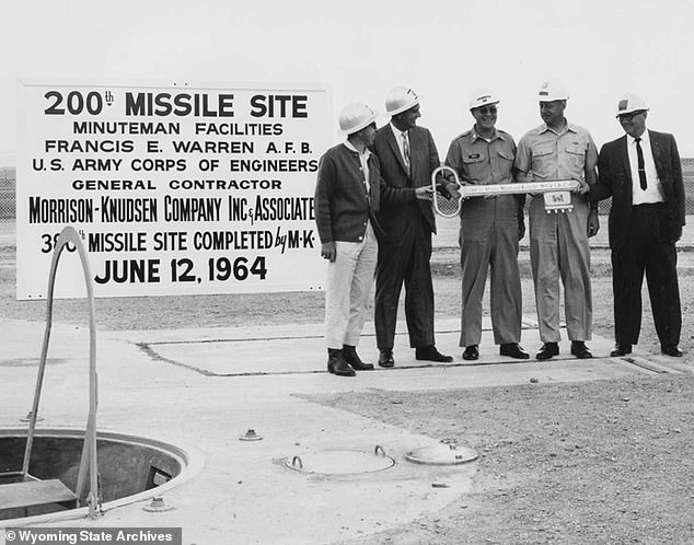 Underground silos, armed with Cold War-era Minuteman III intercontinental ballistic missiles (ICBMs), have sat behind anonymous fences inside farms and ranches for over half a century. Above, local contractors celebrate completion of a 200th missile silo in Wyoming in 1964