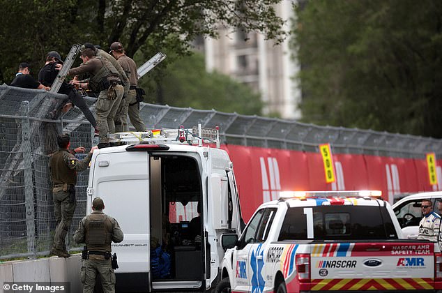 Police scaled the fence roughly 40 minutes after the protestors chained themselves to it and arrested them on suspicion of criminal trespassing