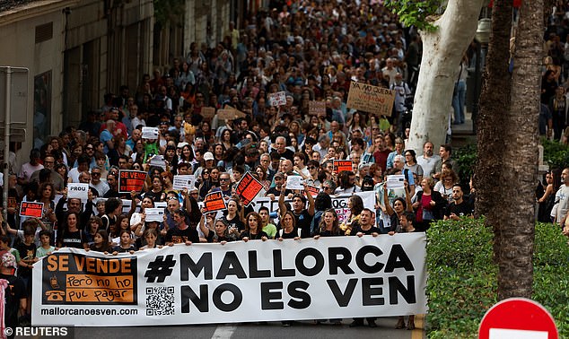 In May, 10,000 people marched in Palma de Majorca against tourism, above. The sign reads 'Mallorca [Majorca] is not for sale'