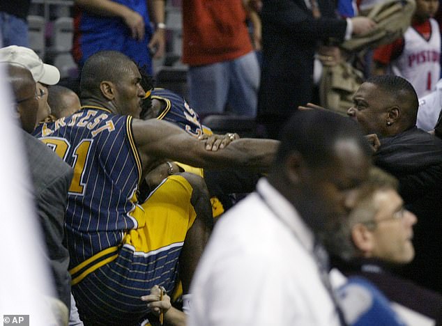 Ron Artest (left) was at the center of the NBA's worst ever fight when he darted into the crowd during the Pacers' game against the Pistons and fought with fans