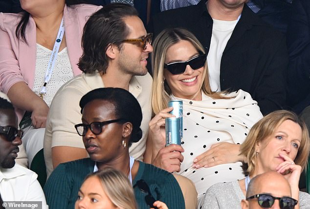 Margot rested her hand on her blossoming baby bump