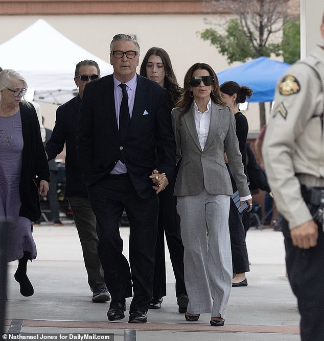 Baldwin holds hands with his wife Hilaria as he exits the courthouse on Friday, moments after his manslaughter case was dismissed by a judge