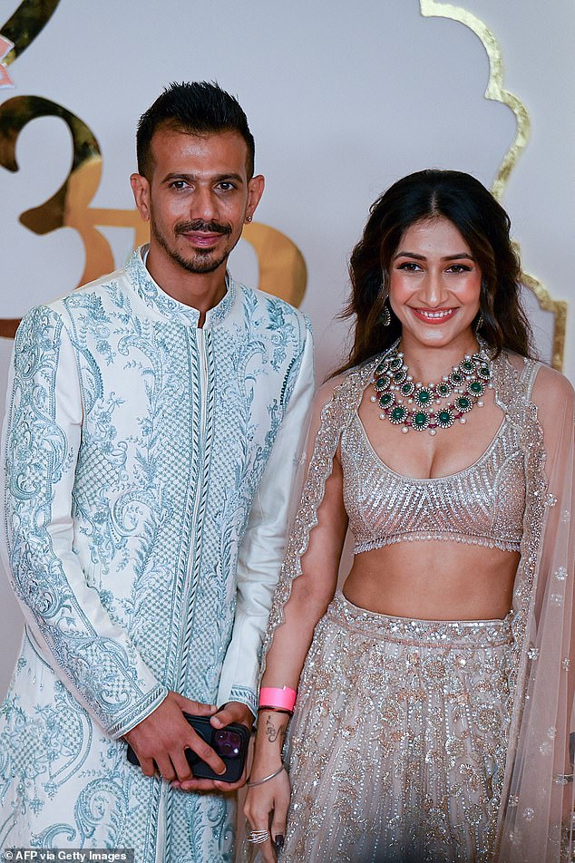 Indian cricket player Yuzvendra Chahal (L) poses with his wife Dhanashree Verma as they arrive to attend the wedding ceremony of billionaire tycoon and Chairman of Reliance Industries Mukesh Ambani's son Anant Ambani and Radhika Merchant in Mumbai