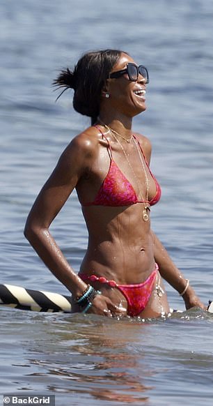 The supermodel, 54, showed off her toned physique in a skimpy red bikini and accessorised with a gold pendant