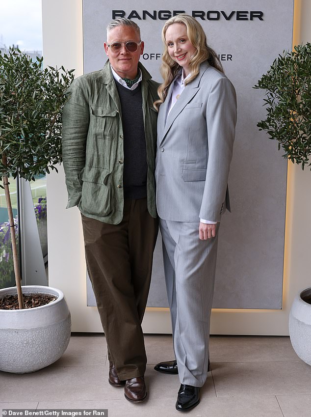 The celebrity also took up the chance to get snapped with British fashion designer Giles Deacon who cut a smart figure in a dark grey knitted vest and brown trousers