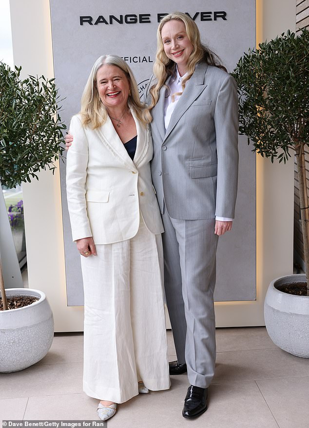 She teamed the smart suit with a pair of shiny black leather shoes as she posed with Lydia Slater, Harper's Bazaar Editor-In-Chief