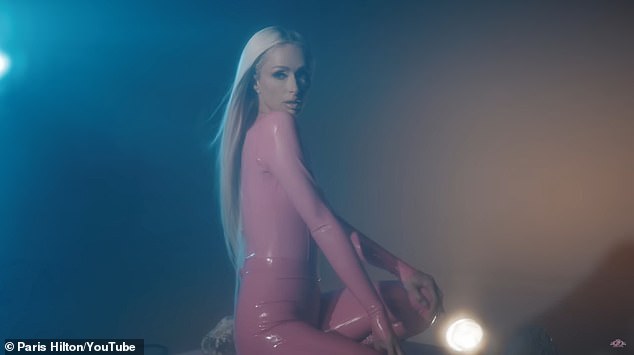 The mother of Phoenix, 18 months, and daughter London, eight months, with husband Carter Reum 43, shimmed around in a skin tight light pink shiny dress at various points in the video