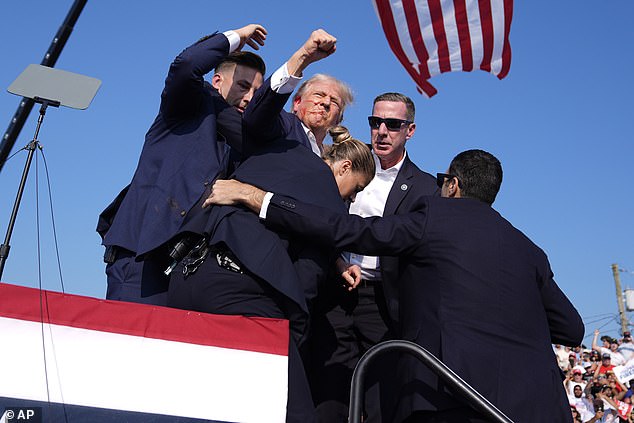 Former President Donald Trump fist pumped to a crowd of his supporters as he was escorted off the stage after shots were fired at his rally