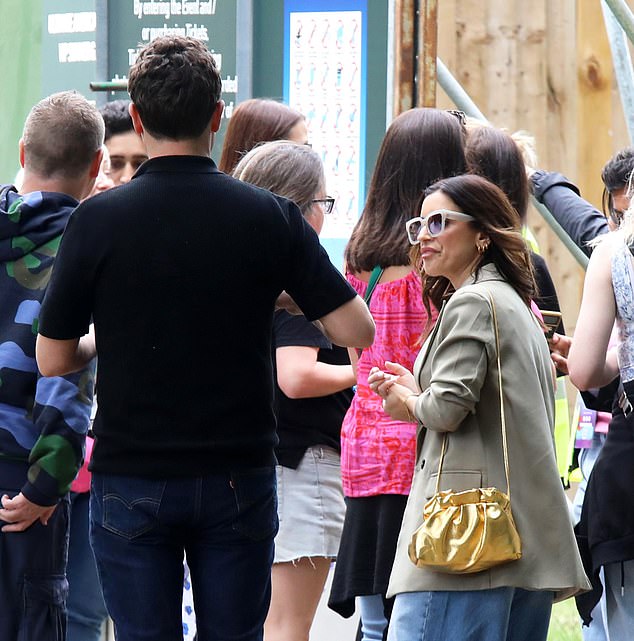 She added a khaki oversized blazer over the ensemble and kept comfortable in a pair of white trainers.