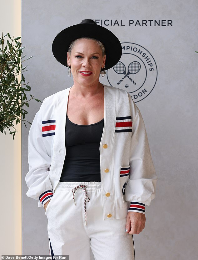 The Just Give Me a Reason hitmaker, 44 ¿ who recently showed off her bikini body while on vacation ¿ posed for photos in a white cardigan and pants with navy and red stripe details on the outfit's pockets and wrists