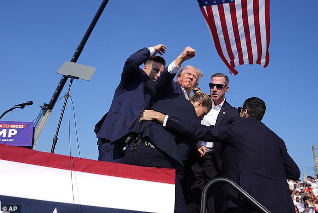 Republican presidential candidate former President Donald Trump gestures as he is surrounded by U.S. Secret Service agents as he leaves the stage at a campaign rally, Saturday, July 13, 2024, in Butler, Pennsylvania