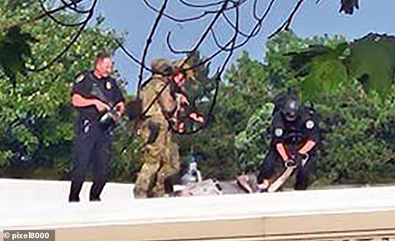 Pics show: Police surround what appears to be the body of the shooter on the roof. pice posted on XDonald Trump apparently shot and injured in the ear - is carried off bleeding and punching the air by securty services in Butler14.7.24X supplied by Pixel8000check permissions before use 07917221968