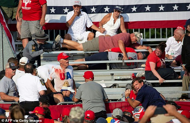 The emergency room doctor can be seen tending to a victim as panicked rallygoers cowered and fled for safety