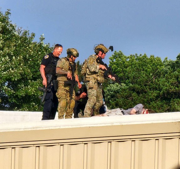 Police personnel standing over the body of the shooter on a rooftop near the Trump rally in PA July 13th.He was taken out by police snipers already set up, near the stage...