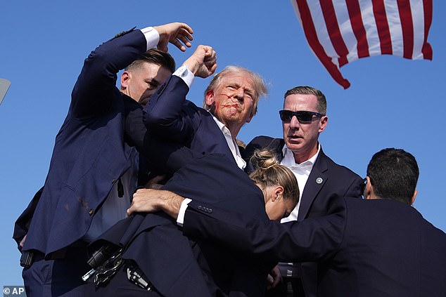 Seconds after falling to the floor after taking the shot to his ear, Trump stood up and triumphantly raised his fist to show his supporters he was not severely injured