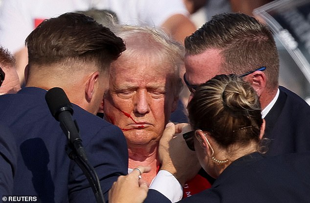 Trump is seen surrounded by Secret Service agents in the moments after the shooting