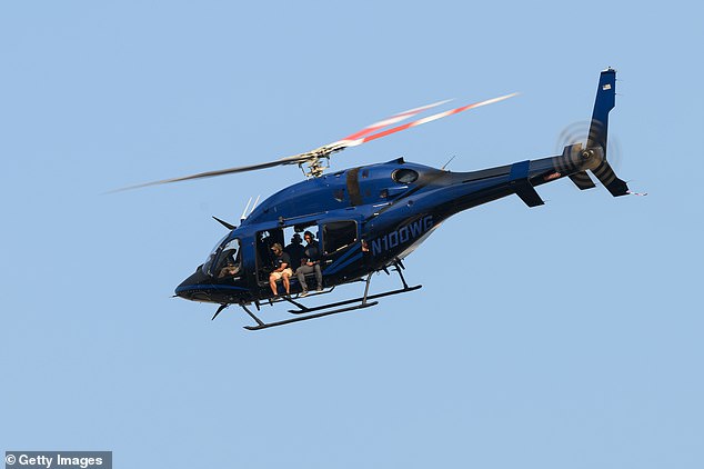 A helicopter flies overhead some time after Trump was raced away from the scene