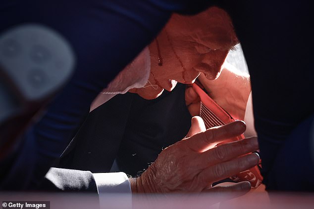 Stunning images showed Trump cowered on the floor as agents protected him, with blood dripping down his cheek