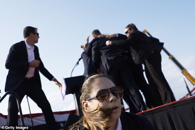 US Secret Service agents surround Trump and the stage after shots are fired