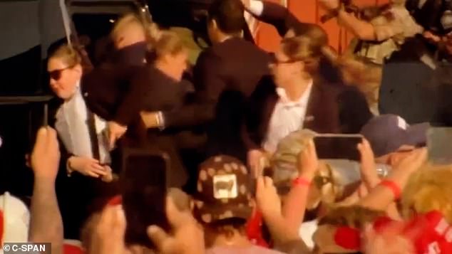 There were chaotic scenes as the former President was bundled into a black SUV, with a Secret Service agent appearing to struggle to holster her weapon