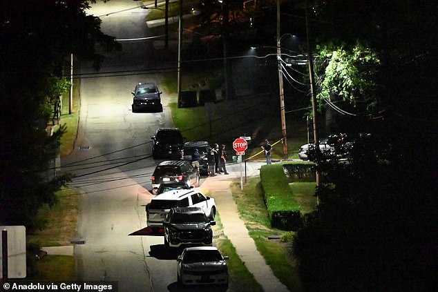 Officers stand guard outside a cordon in Bethel Park as cops search an address registered to Crooks