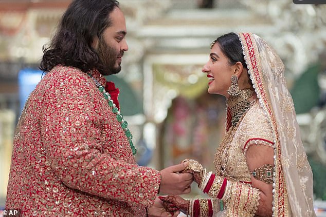 Anant Ambani, left, the son of billionaire Mukesh Ambani, holds hands with Radhika Merchant during their wedding ceremony at Jio World Convention Centre in Mumbai, India, on Friday