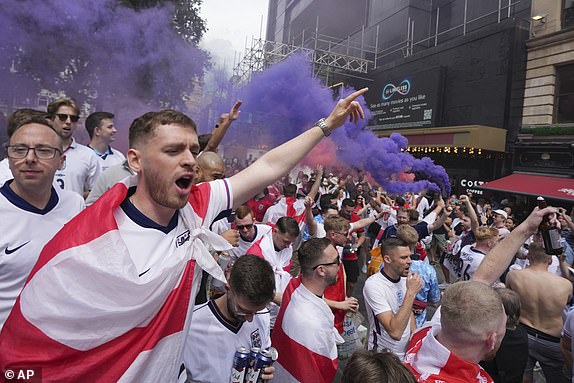 England fans chant and light flares as they enjoy the atmosphere in Leicester Square, London, Sunday, July 14, 2024, ahead of the Euro 2024 Final soccer match between Spain and England, being played in Berlin later Sunday.(AP Photo/Kin Cheung)