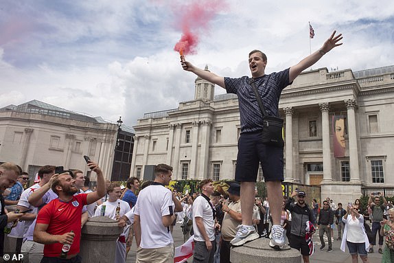 England fans light flares fans and enjoy the atmosphere in Trafalgar Square, London, Sunday, July 14, 2024, ahead of the Euro 2024 Final soccer match between Spain and England, being played in Berlin later Sunday. (AP Photo/Thomas Krych)