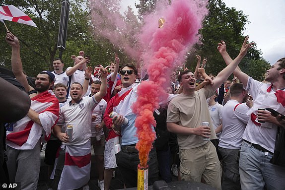 England fans light flares and enjoy the atmosphere in Leicester Square, in London, Sunday, July 14, 2024, ahead of the Euro 2024 Final soccer match between Spain and England, being played in Berlin later Sunday. (AP Photo/Kin Cheung)