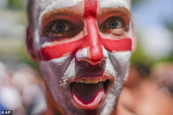 A man with face painted in the colours on the English flag gestures at Breitscheidplatz before the start of the final match between Spain and England at the Euro 2024 soccer tournament in Berlin, Germany, Sunday, July 14, 2024. (AP Photo/Ariel Schalit)