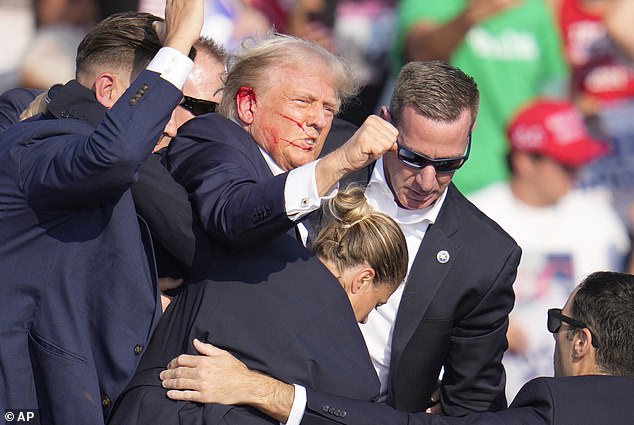 Blood is seen coming from Donald Trump's ear, where he said he was shot. Trolls online claimed the event was staged immediately after it happened