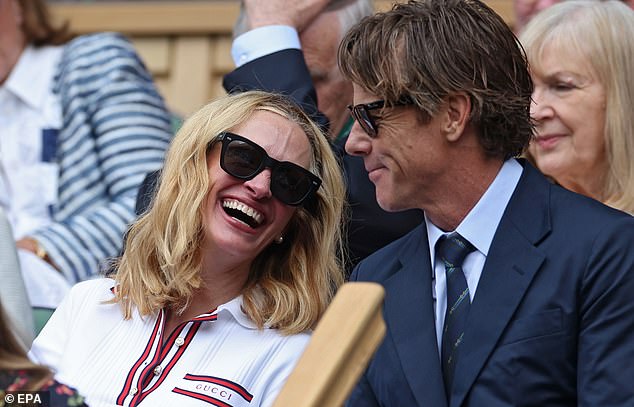 Julia Roberts wears a Gucci top as she shares a light hearted moment with her husband Daniel Moder