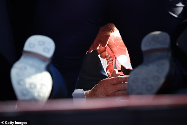 An extraordinary photo shows Donald Trump on the ground at Butler Show Grounds in Pennsylvania Saturday after he was injured in a shooting that left two people dead