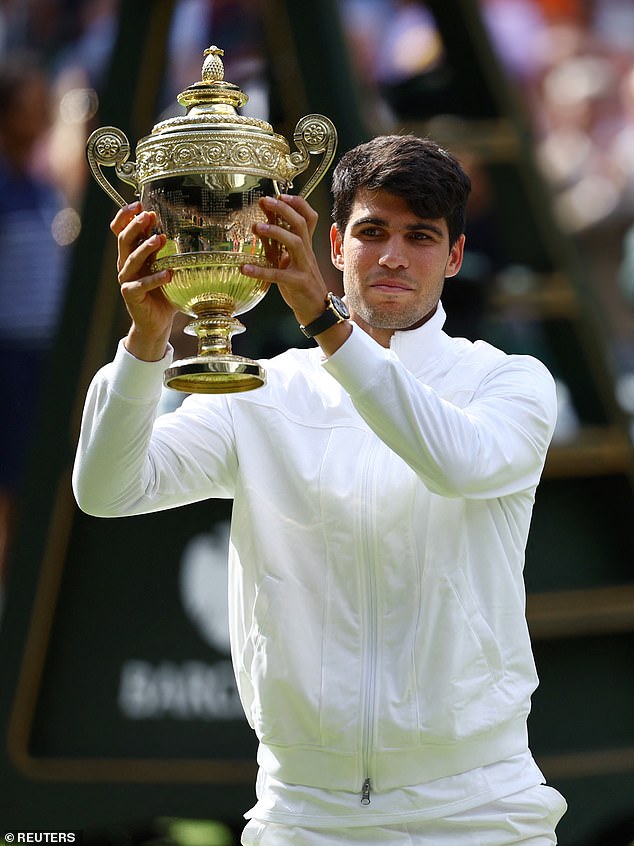 Spain's Carlos Alcaraz poses for a picture with the trophy after winning in three sets