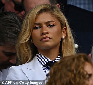 She caught the eye in a smart white trouser-suit and pinstripe shirt, teamed with a loosely knotted navy tie