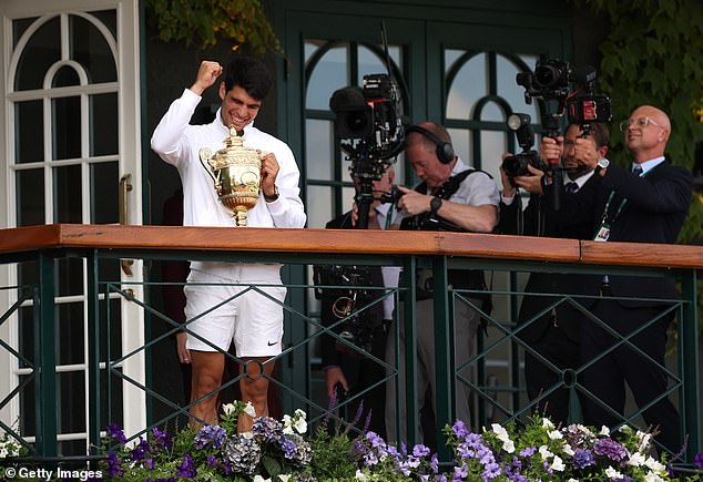 Carlos Alcaraz celebrates with the Gentlemen's Singles trophy from the Clubhouse Balcony