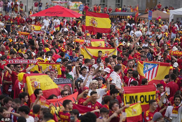 Fans of Spain wave flags and cheer in Berlin fair before the start of the final match between Spain and England