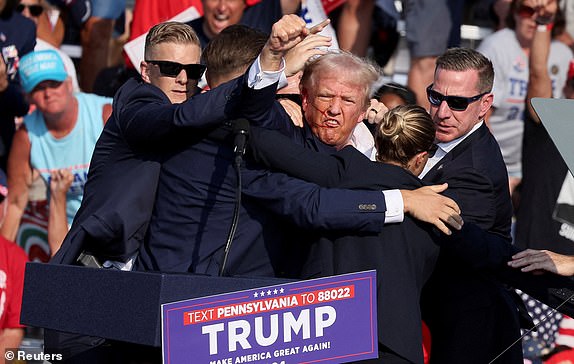 FILE PHOTO: Republican presidential candidate and former U.S. President Donald Trump gestures with a bloodied face while he is assisted by U.S. Secret Service personnel after he was shot in the right ear during a campaign rally at the Butler Farm Show in Butler, Pennsylvania, U.S., July 13, 2024. REUTERS/Brendan McDermid/File Photo