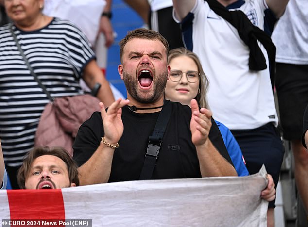 An England fan cheering in the stands ahead of kick-off